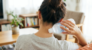 美容院の入店前に首の後ろをペットボトルで冷やして汗対策をする様子。